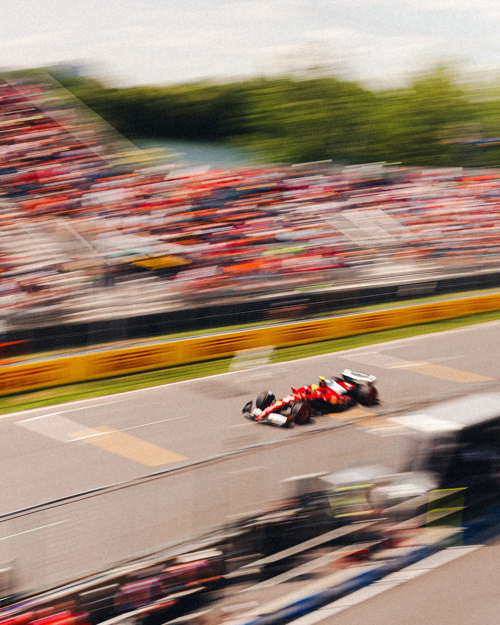 Panning shot of a Ferrari blurring between the grandstands