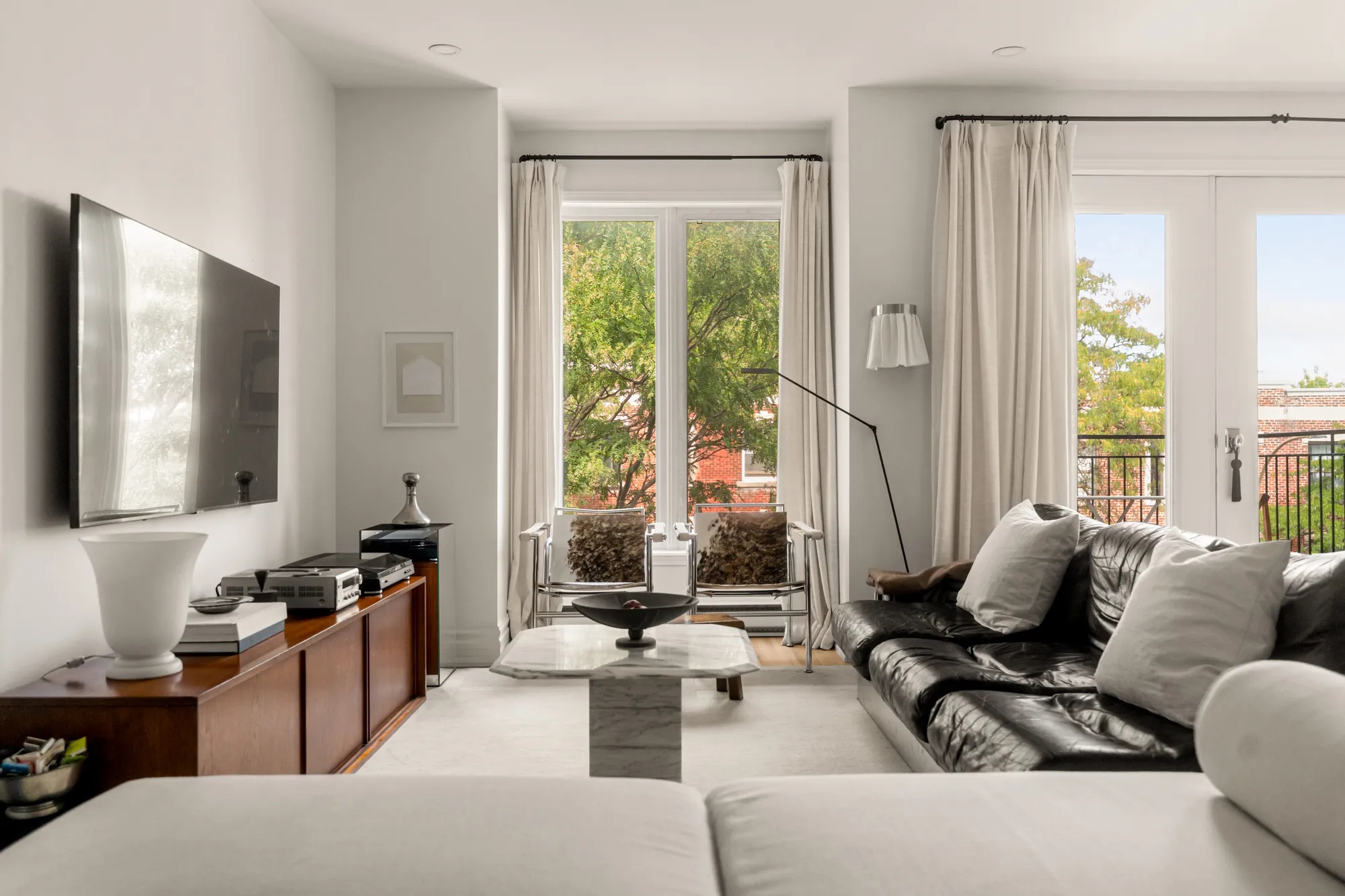 Lounge with French windows and black leather sofa
